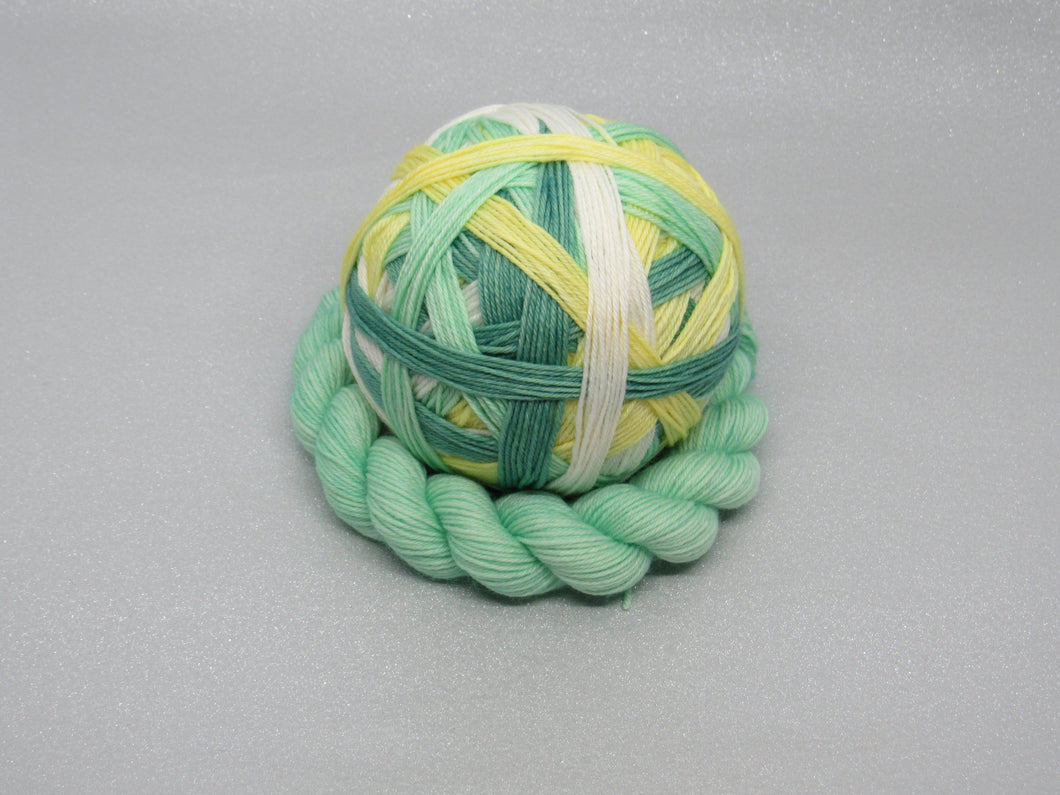 Deluxe Merino Nylon Self Striping Yarn in the Christmas Rose colourway with a coordinating mini skein