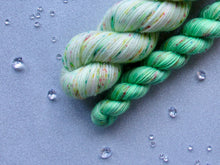 Load image into Gallery viewer, Silver Sparkle 4ply 50g in Christmas In July colourway Festive Speckles with a mini skein in Speckled Green